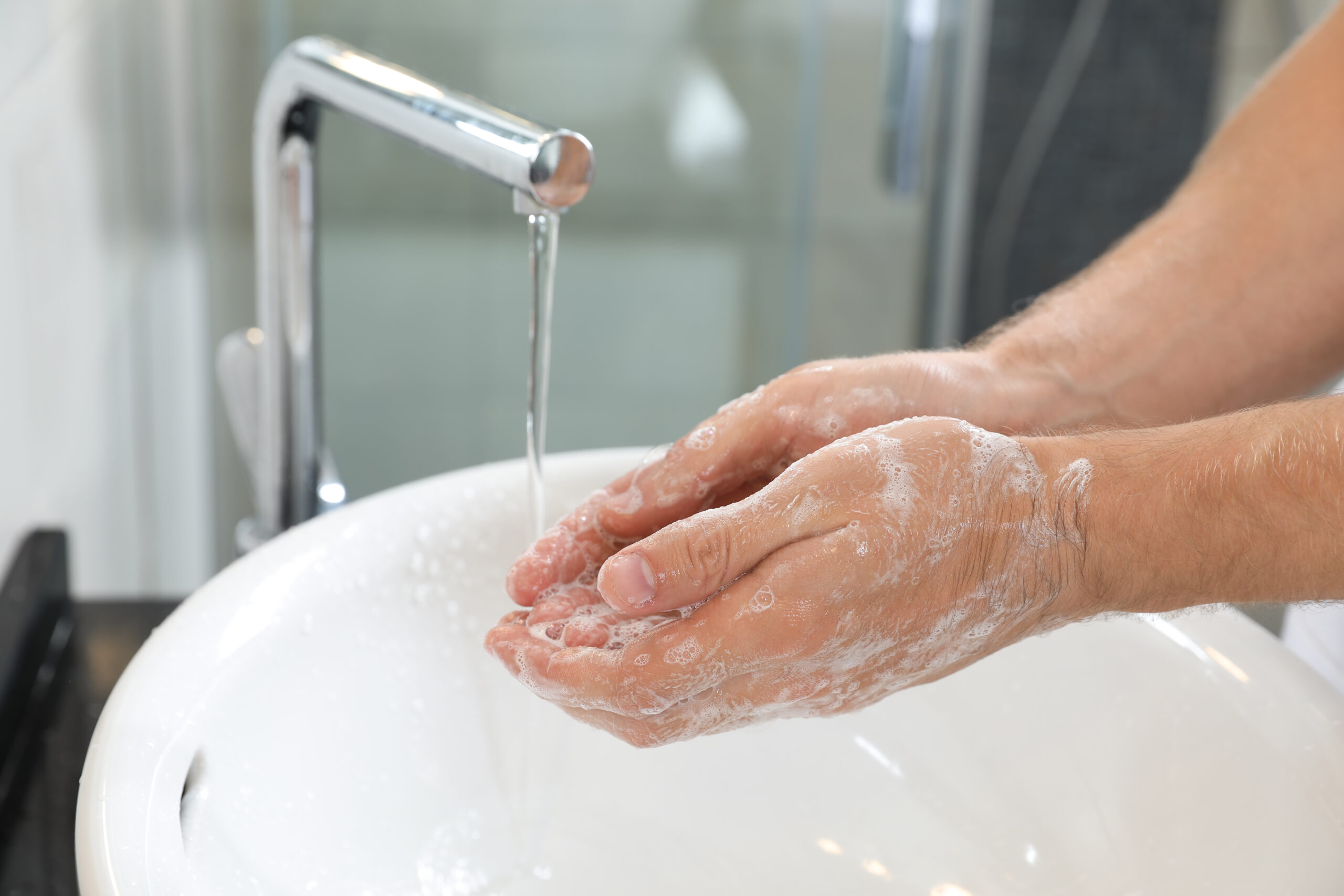 Imagem ilustração paraMan,Washing,Hands,With,Soap,Over,Sink,In,Bathroom,,Closeup